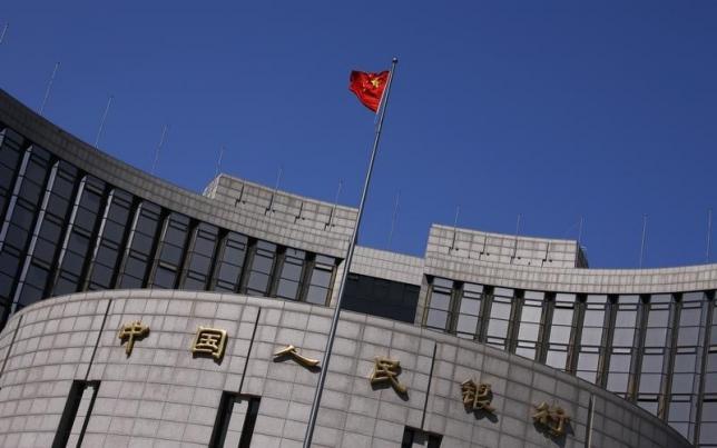 A Chinese national flag flutters outside the headquarters of the People's Bank of China in Beijing